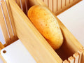A close-up of a bagel placed inside the adjustable bread slicer for easy slicing, highlighting its versatile use.